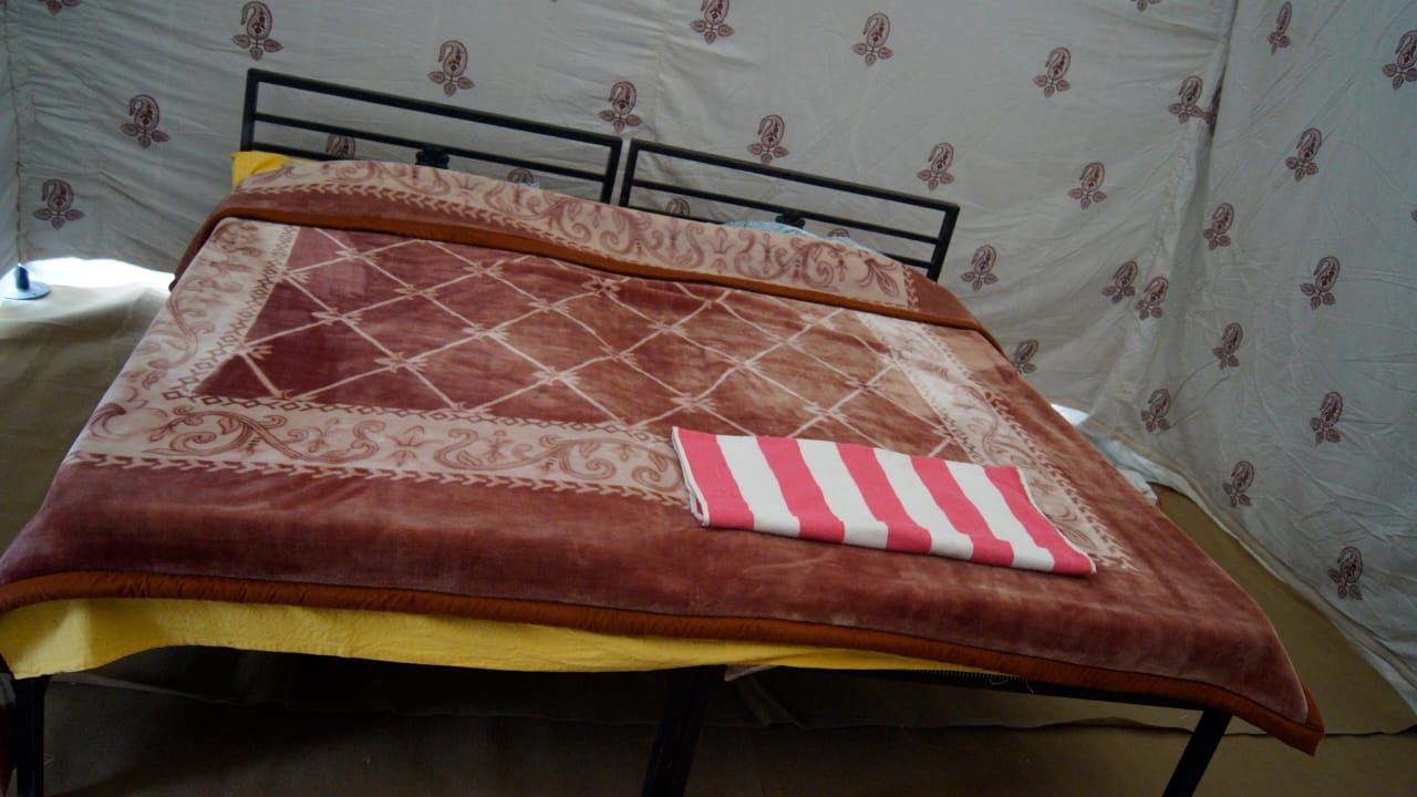 Comfortable bed inside a desert tent at an Osian desert camp in Rajasthan